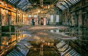 walls with graffiti of an abandoned building in water reflection