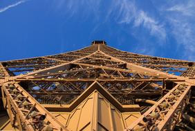 Low angle shot of the beautiful Eiffel Tower at blue sky with white clouds on background, in Paris, France