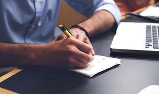 a man taking notes in a notebook