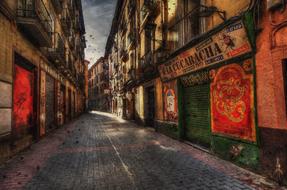 Beautiful and colorful street, with the pavement, in Spain, under the cloudy sky