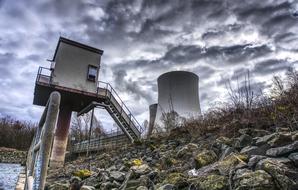 Nuclear power plant, among the colorful stones and grass near Rhine, under cloudy sky in Germany