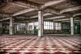 Beautiful, old building with the colorful graffities, columns and red and white mosaic tile