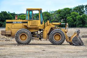 a bulldozer with a bucket digs the ground