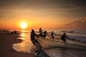 silhouettes of fishermen on the coast in vietnam