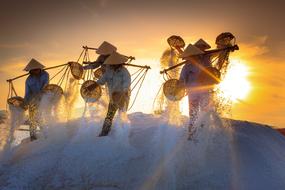 People on the beautiful salt field in Nha Trang in Vietnam, at colorful and beautiful dawn