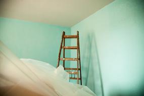 Ladder of the painter, in light, among the turquoise walls