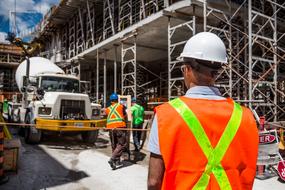 construction workers in safety helmets and vests