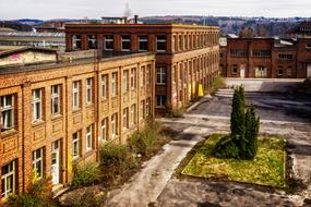 Old factory buildings, with the colorful plants, near the mountains