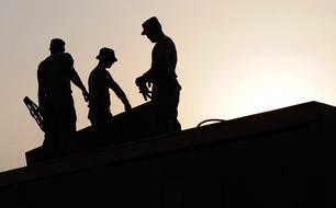 silhouette of three Workers on Construction Site