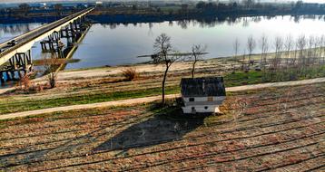 cottage and arable field by the river in Lombardy, Italy