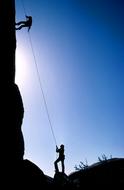 silhouettes of rock climbers in the bright sun