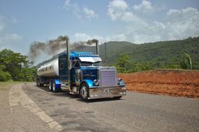 blue truck carrying petroleum products on a highway