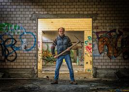 Man with pickaxe among the abandoned building with colorful graffities