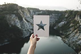 photo of snowy mountains and mountain lake through a starry frame