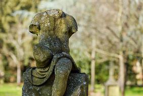 headless sculpture on a grave in an old cemetery