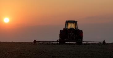 tractor in the field at dusk