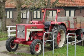 red tractor with a trailer on a farm