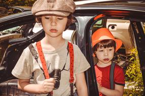 retro photo of two boys on the background of an old car