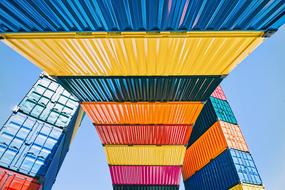 cargo containers of different colors on a blue sky background