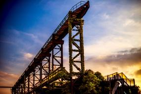 industrial Construction overgrown with ivy at Sunset sky