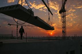 worker, concrete slab and crane at construction site