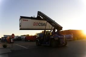 Loading crane with the container in the port at colorful and beautiful sunrise near the Rhine in Germany