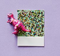 sparkles on a sheet and a toy dinosaur