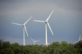 white wind stations over green trees