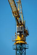photo of a construction crane with an arrow against a blue sky