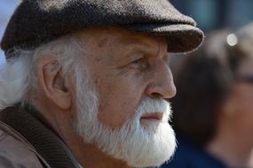 Old man with white beard, in dark cap, in light, in Hamburg, Germany