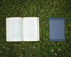 open book and tablet are on the lawn