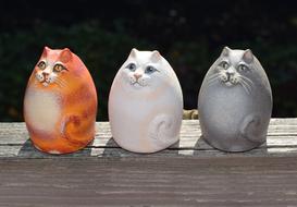 Colorful, beautiful and cute ceramic cats on the wood in light