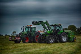 Colorful Deutz and Fendt 820 tractors on the colorful field, under the cloudy sky