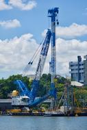 blue and white industrial crane by the river