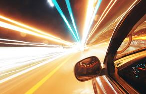car on road and light traces at night