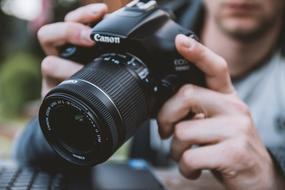 SLR camera in hands close-up on a blurred background