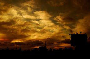 stormy sky with dark clouds over an industrial plant