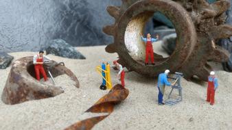 figures of builders on the background of rusty details in the sand