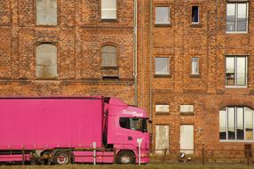 pink truck on the background of an old brick building