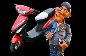 Figure of an auto mechanic with the red, black and white scooter, at black background