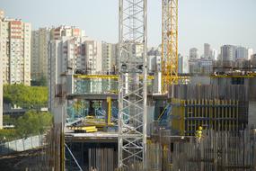 Workers on the new construction, among the city and plants