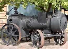 Steam-Engine Vintage vehicle near the tree in the museum