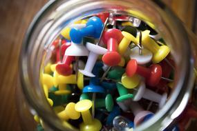 Colorful pins with the needles, in the glass jar