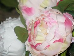 Close-up of the colorful and beautiful paper flowers with green leaves