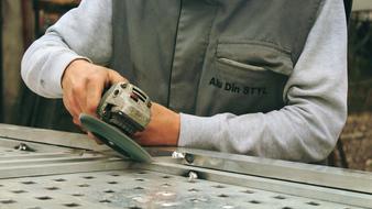 worker polishes a metal structure