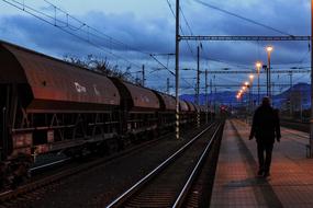 a man walks on a platform near the railway