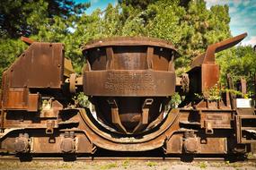 metal hitch of railway cars on background with green plants