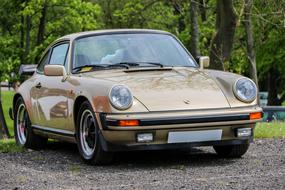 Beige retro Porsche 911is parked on the street