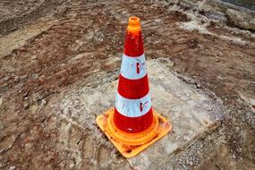 striped road cone at a construction site