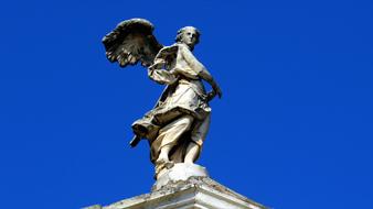 Sculpture Angel Archangel against a bright blue sky